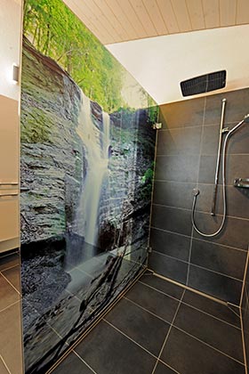 Exklusive Dusche mit Wasserfall-Panoramafoto auf Trennwand aus Glas.