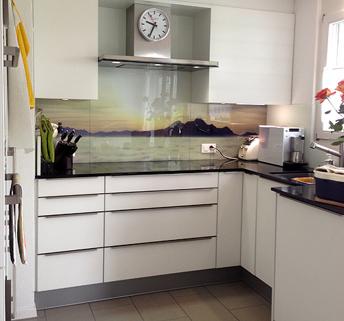 Panoramic photo of an evening atmosphere on a glass kitchen back wall.