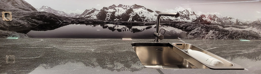 Panoramafoto Spiegelung einer Berglandschaft in kleinem Bergsee in Schwarz/Weiss als Küchenrückwand.