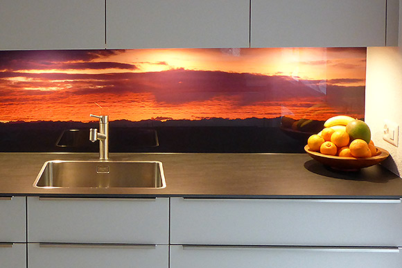 Morgenstimmung mit glühenden Wolken auf Küchenrückwand aus Glas.